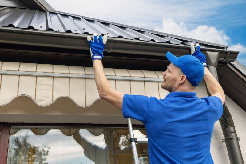 Gutter installation technician working on a roof